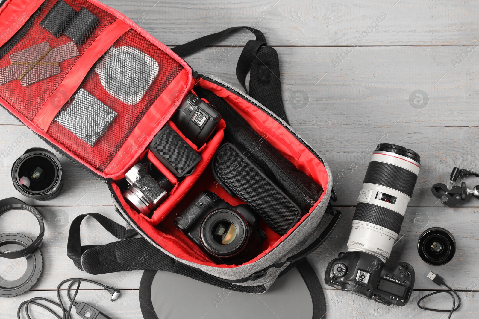 Professional photographer's equipment and backpack on light wooden table, flat lay Photo of Professional photographer's equipment and backpack on light wooden table, flat lay