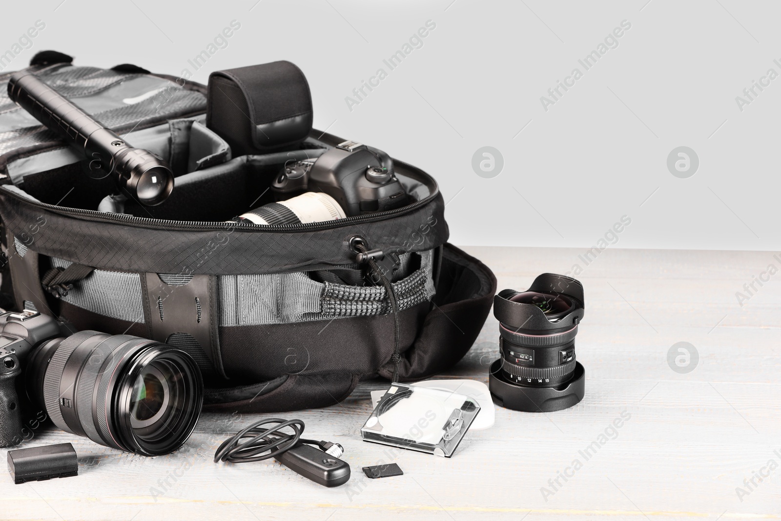Professional photographer's equipment and backpack on light wooden table Photo of Professional photographer's equipment and backpack on light wooden table
