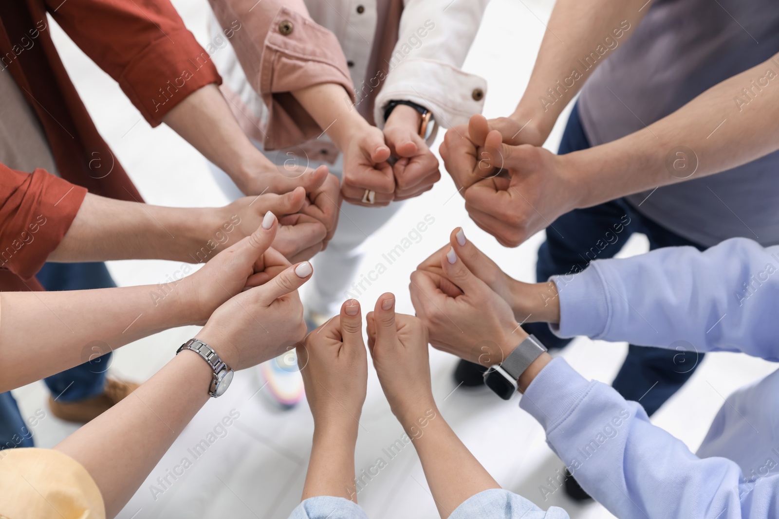 Photo of Unity concept. People showing thumbs up indoors, closeup