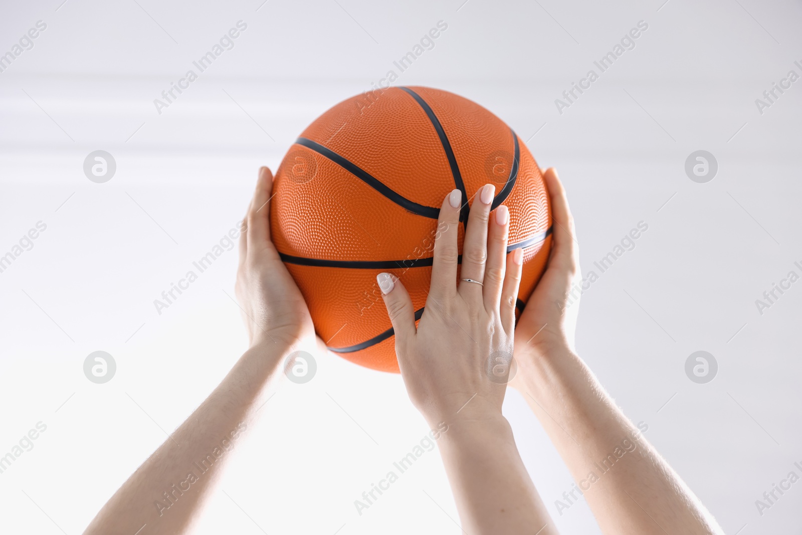 Photo of Unity concept. People holding basketball ball together indoors, closeup