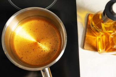 Photo of Used cooking oil in saute pan on stove, above view