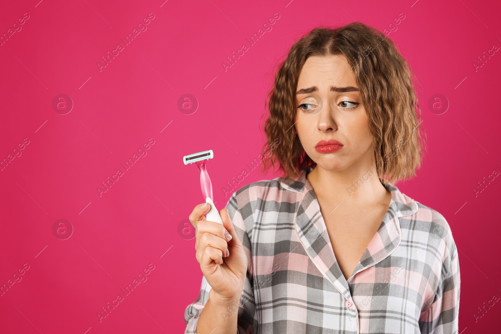 Photo of Emotional woman with razor on pink background, space for text. Hair removal tool