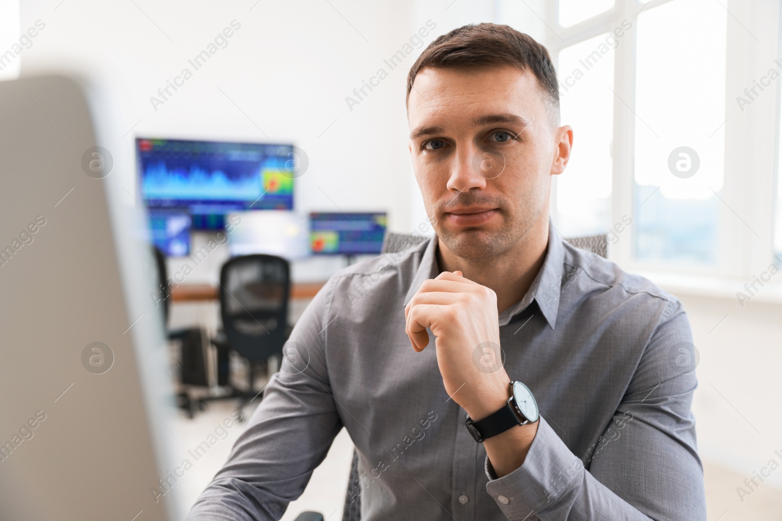 Photo of Financial trading specialist working on computer in office