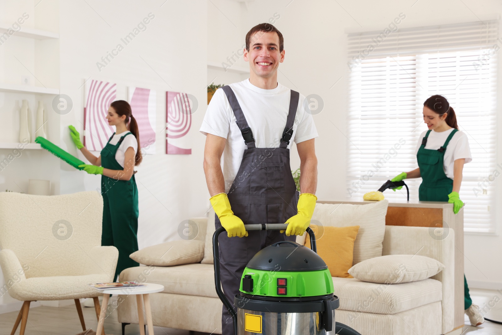 Photo of Professional cleaning service team working in room