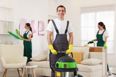 Photo of Professional cleaning service team working in room