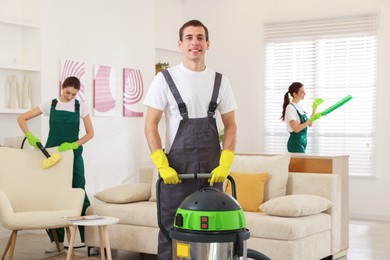 Professional cleaning service team working in room