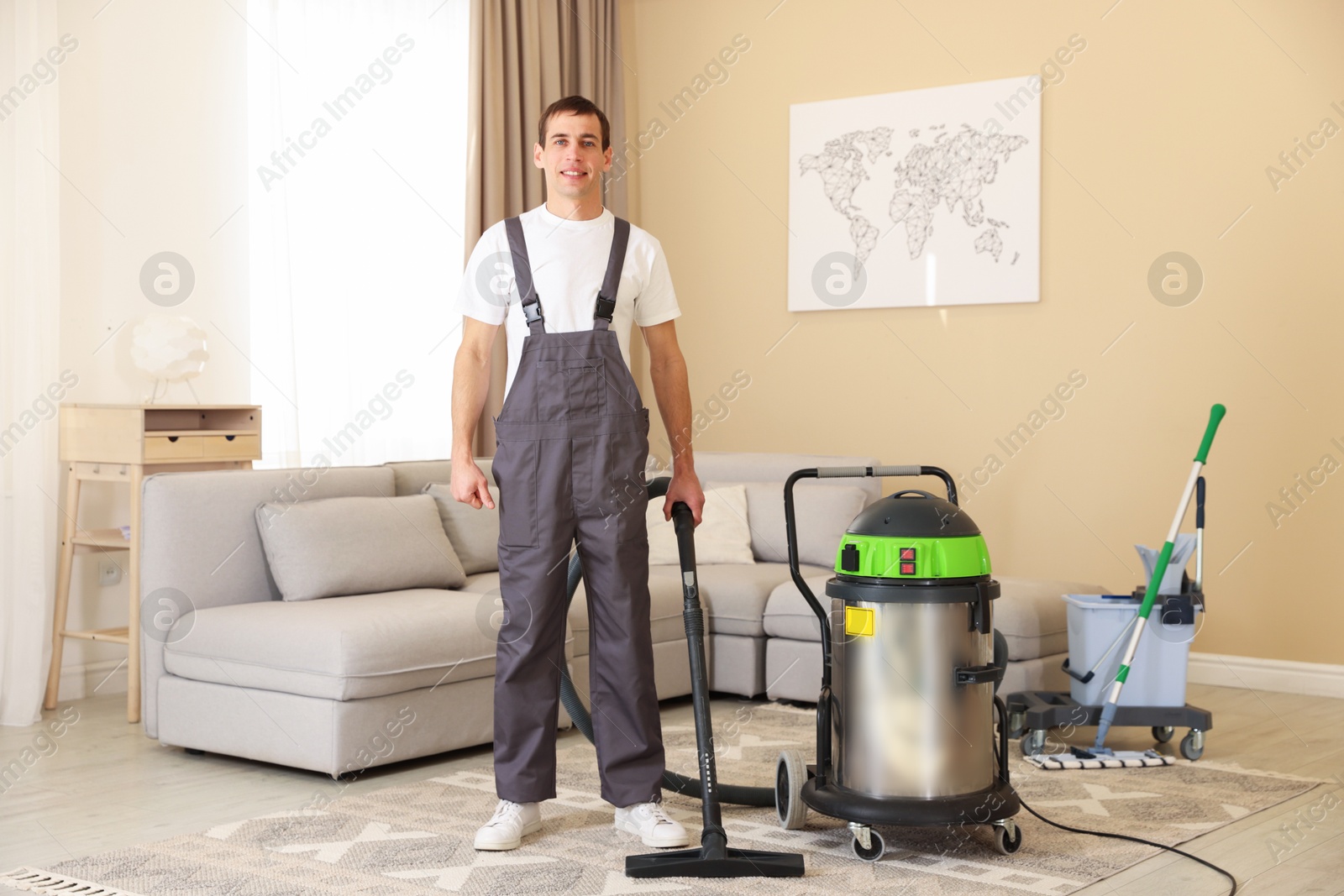 Photo of Cleaning service worker with professional hoover indoors