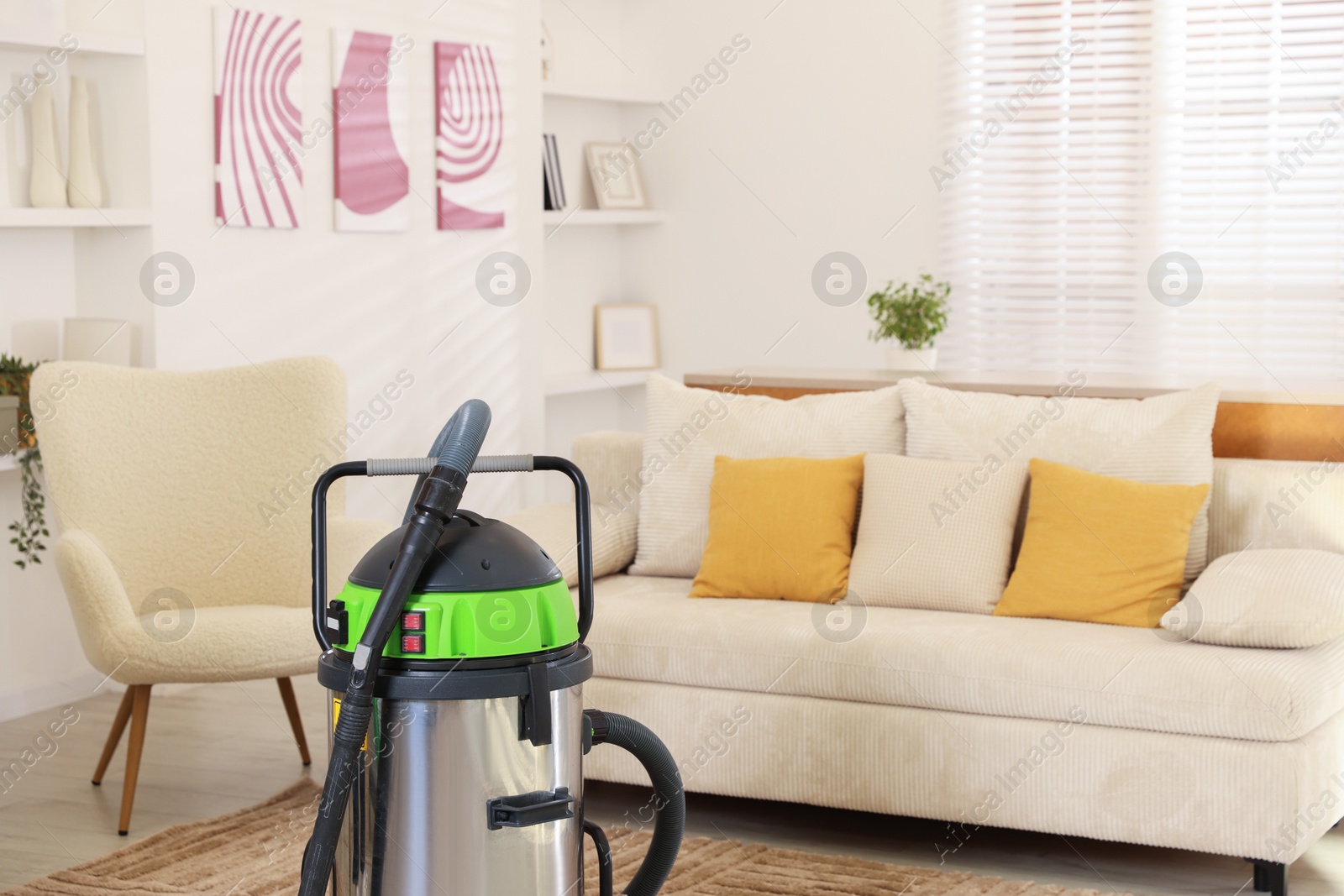 Photo of Professional vacuum cleaner and furniture in room