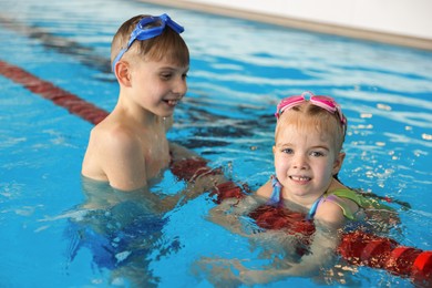 Photo of Children with goggles swimming in pool indoors