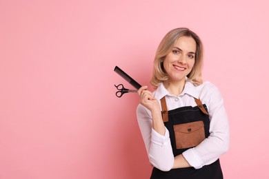 Smiling hairdresser with comb and scissors on pink background, space for text