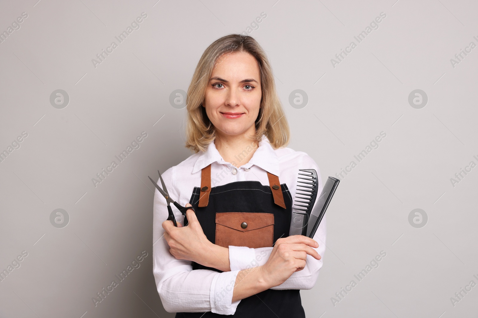 Photo of Hairdresser with combs and brush on gray background