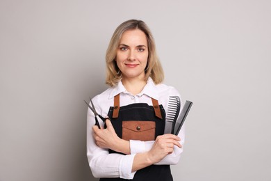 Hairdresser with combs and brush on gray background