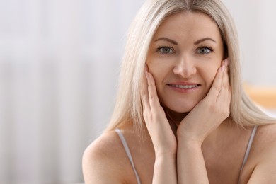 Portrait of beautiful woman with blonde hair indoors. Space for text