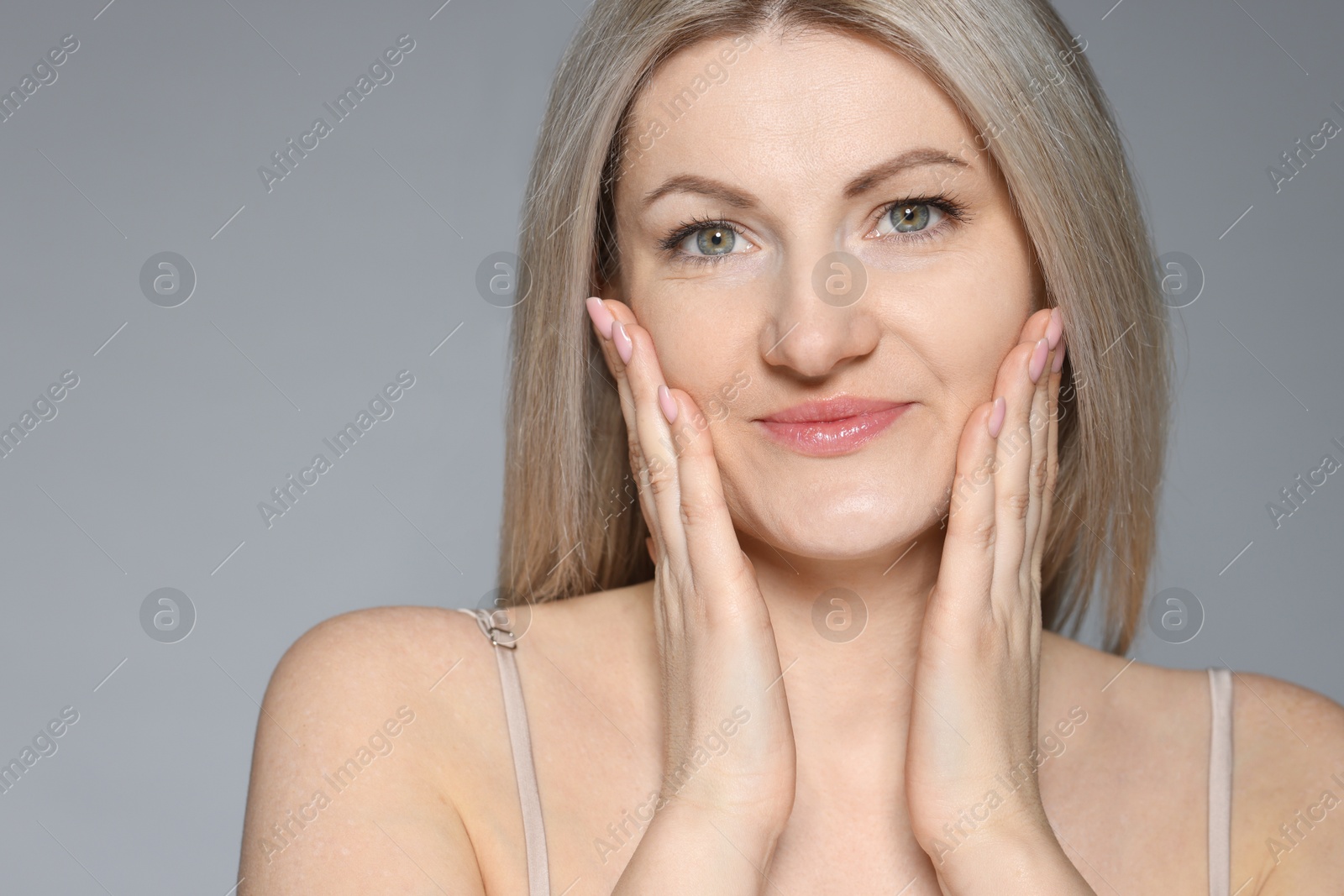 Photo of Portrait of beautiful woman on grey background