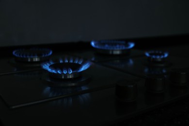 Photo of Gas burners with blue flame on stove, closeup