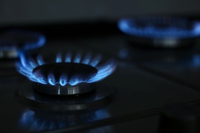 Gas burners with blue flame on stove, closeup