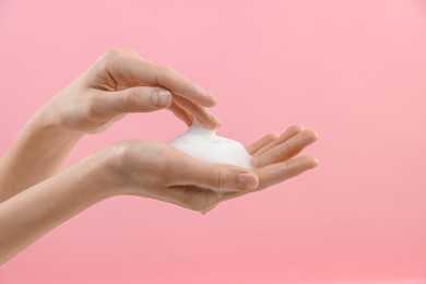 Photo of Woman washing hands with foaming soap on pink background, closeup. Hygiene