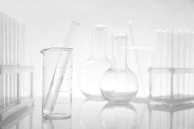 Photo of Laboratory glassware on mirror surface against light background