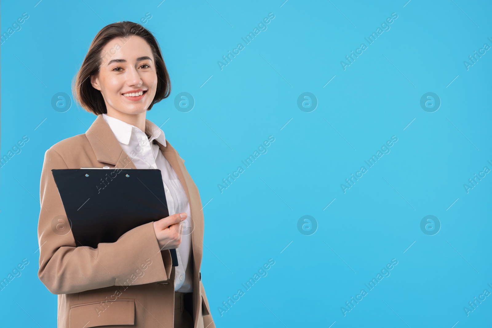 Photo of Portrait of young secretary with clipboard on light blue background. Space for text