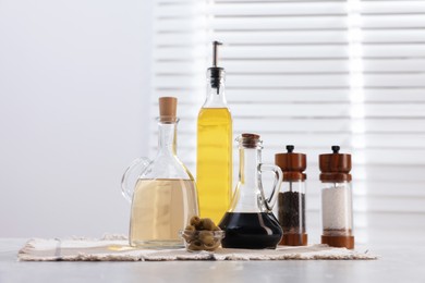 Photo of Salad dressings, spices and olives on table in kitchen