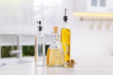 Photo of Salad dressings and olives on table in kitchen