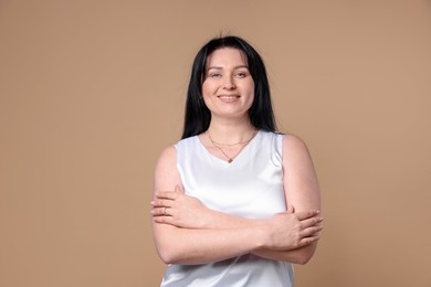 Photo of Portrait of smiling plus size model on beige background. Overweight