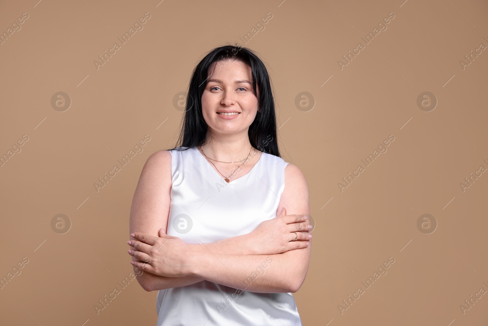 Photo of Portrait of smiling plus size model on beige background. Overweight