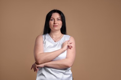 Photo of Portrait of charming plus size model on beige background. Overweight