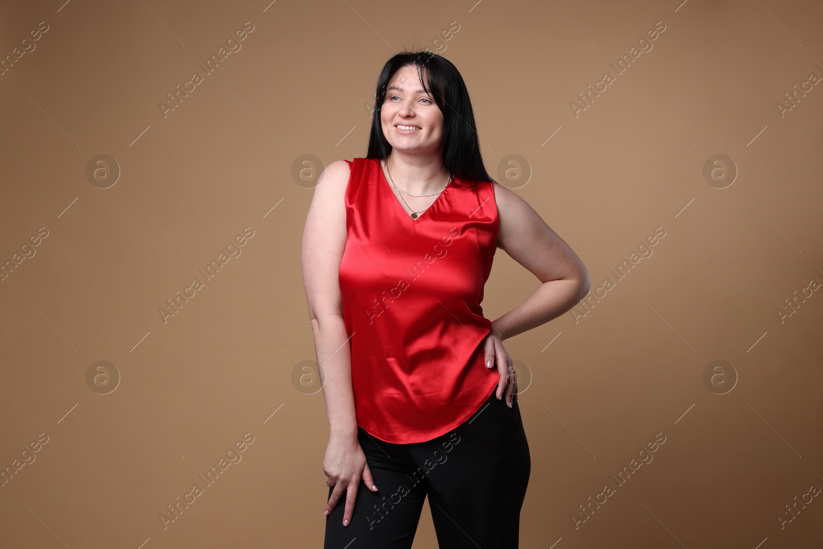 Photo of Portrait of smiling plus size model on beige background. Overweight