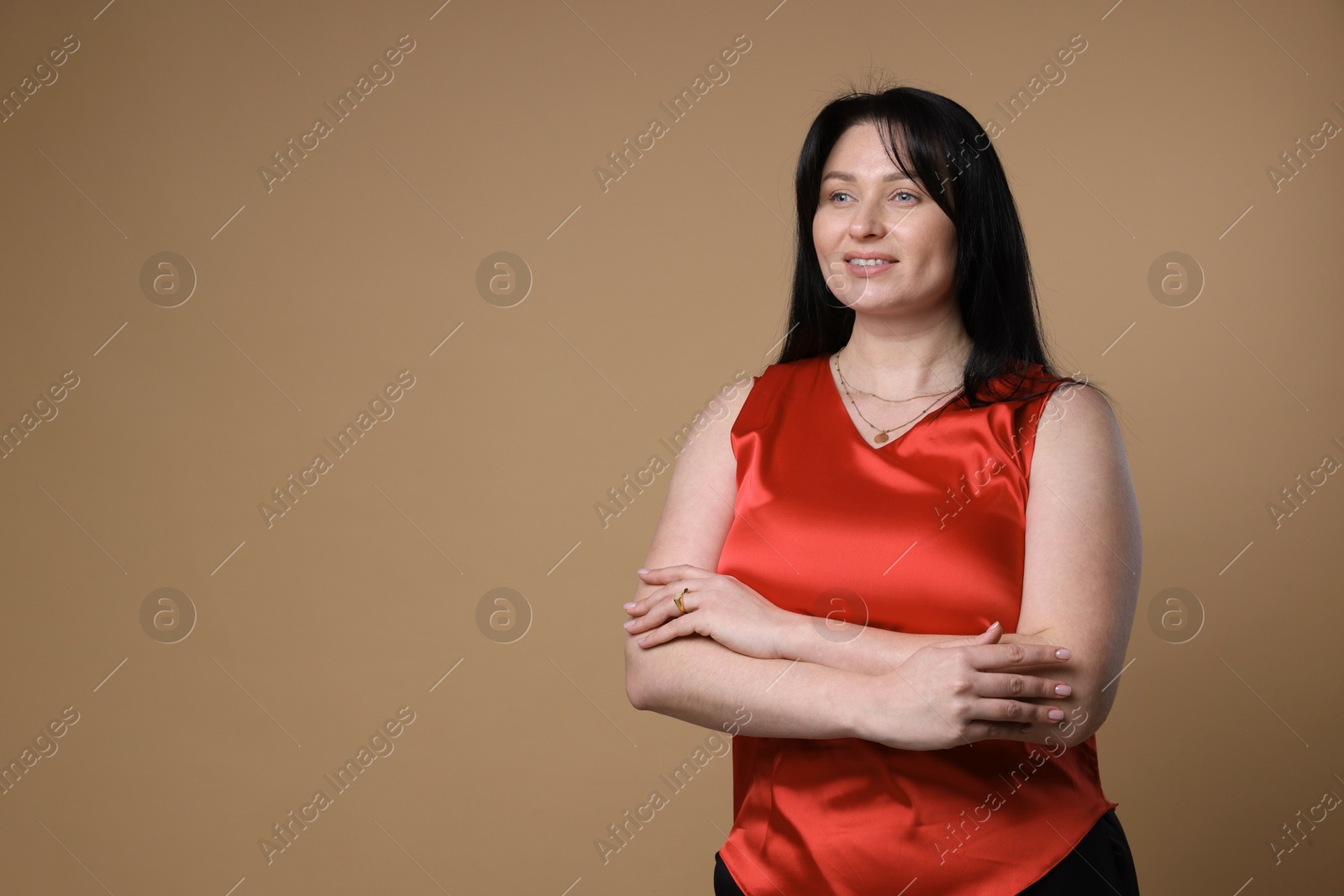 Photo of Portrait of smiling plus size model on beige background, space for text. Overweight