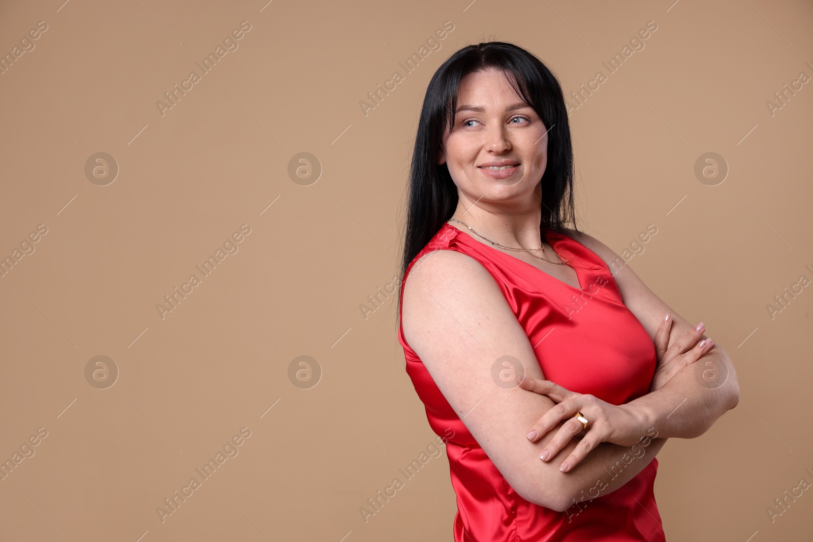 Photo of Portrait of smiling plus size model on beige background, space for text. Overweight