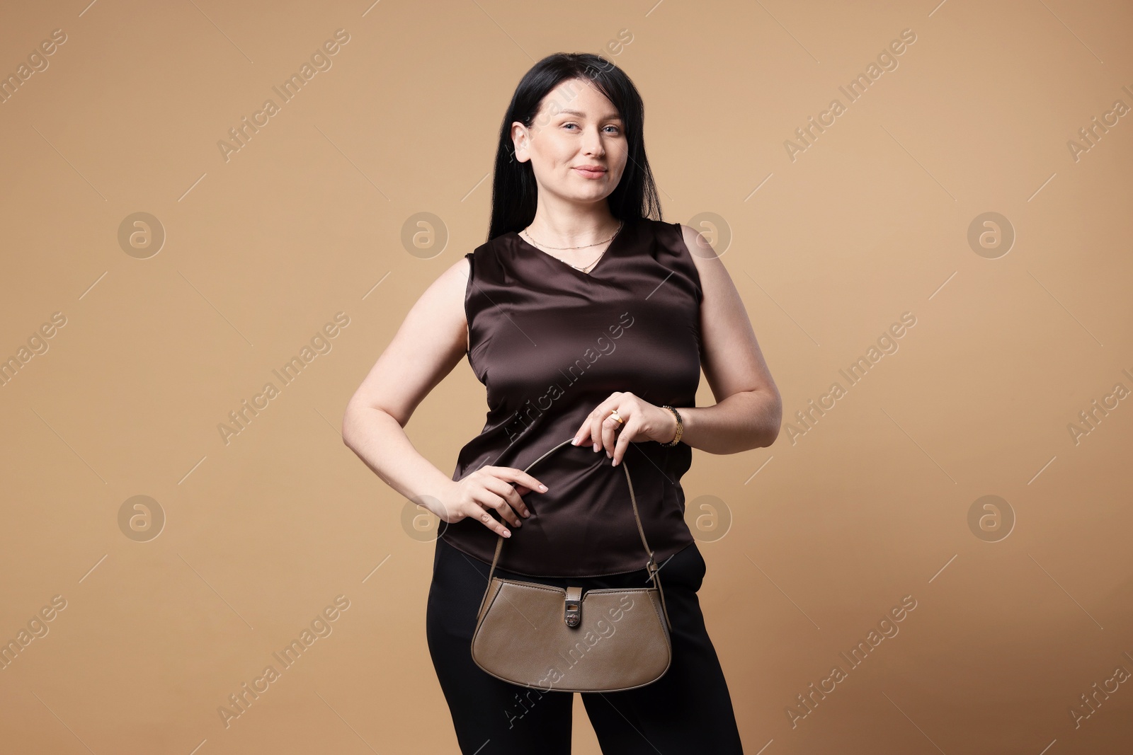 Photo of Elegant plus size model with bag on beige background. Overweight