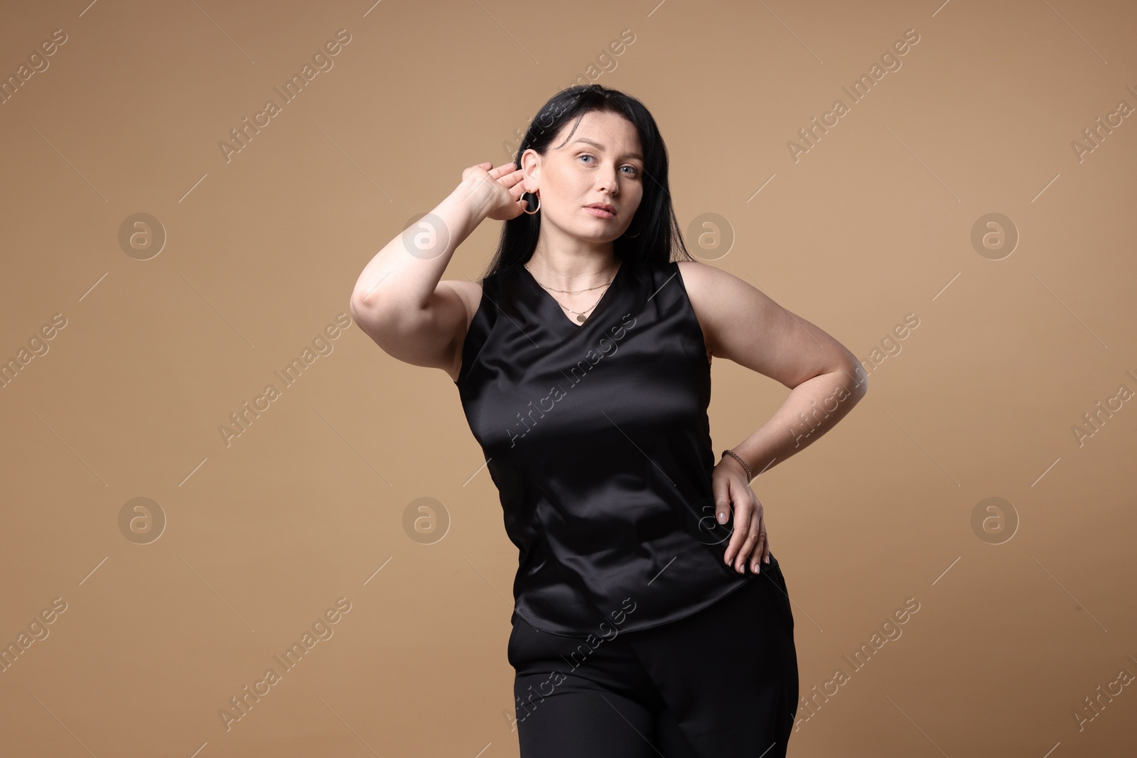 Photo of Portrait of charming plus size model on beige background. Overweight