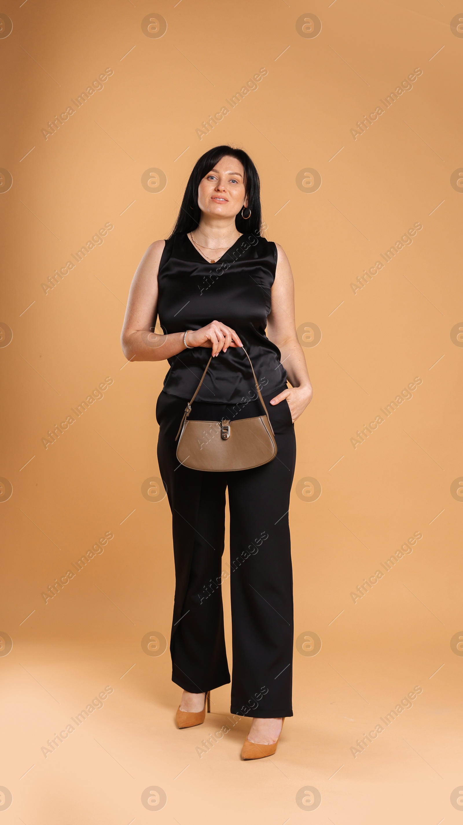 Photo of Elegant plus size model with bag on beige background. Overweight