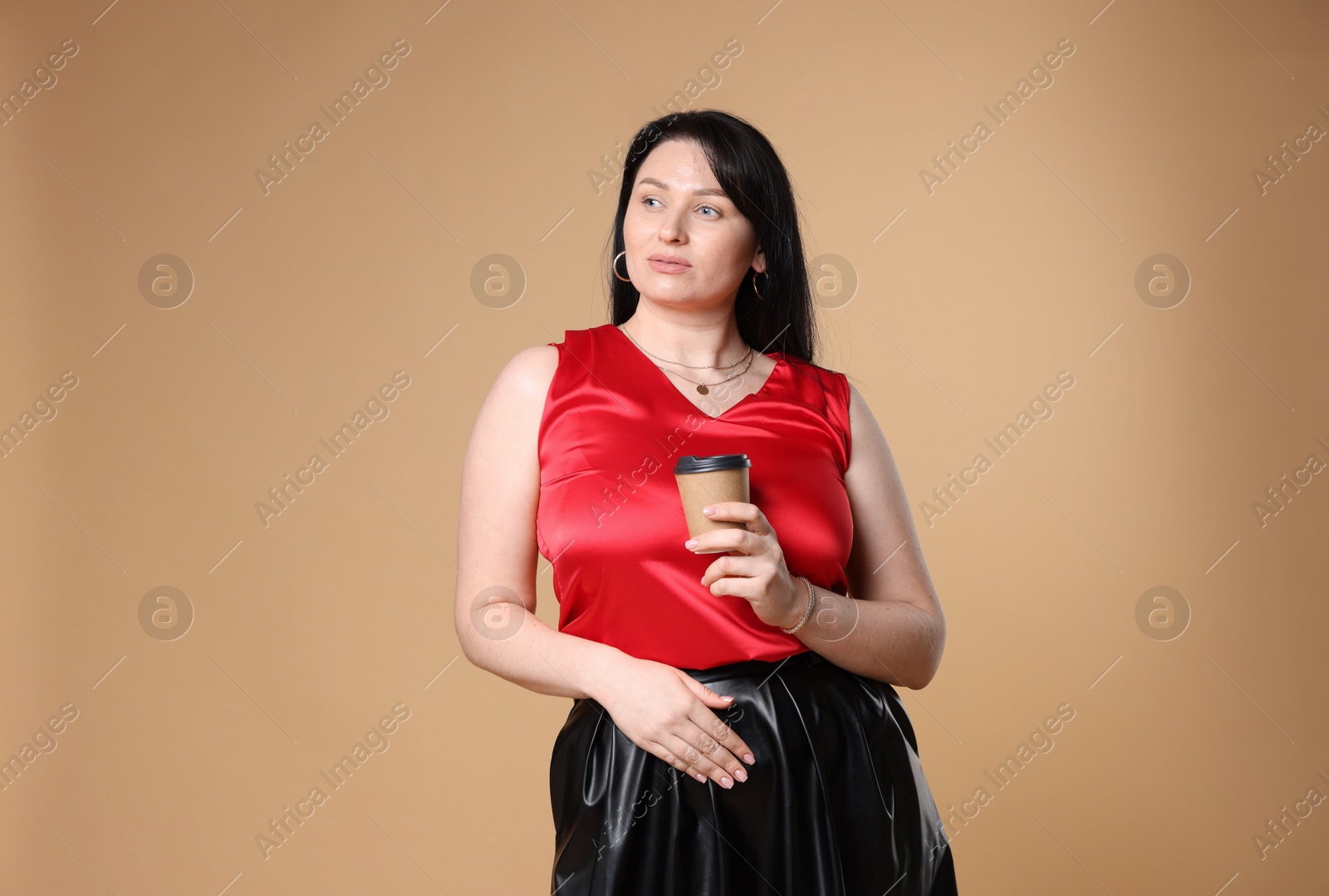 Photo of Charming plus size model with paper cup on beige background. Overweight