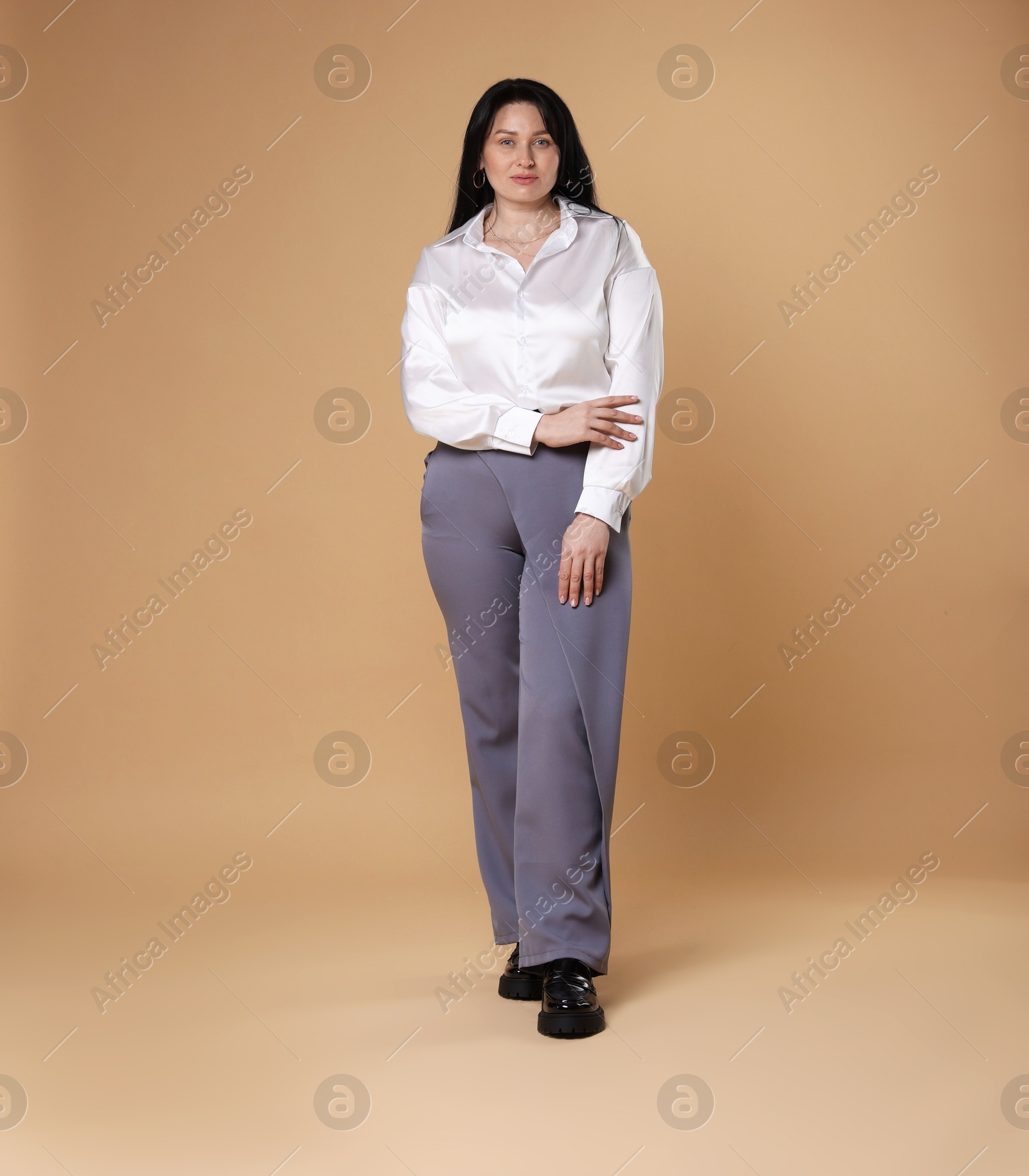 Photo of Charming plus size model on beige background. Overweight