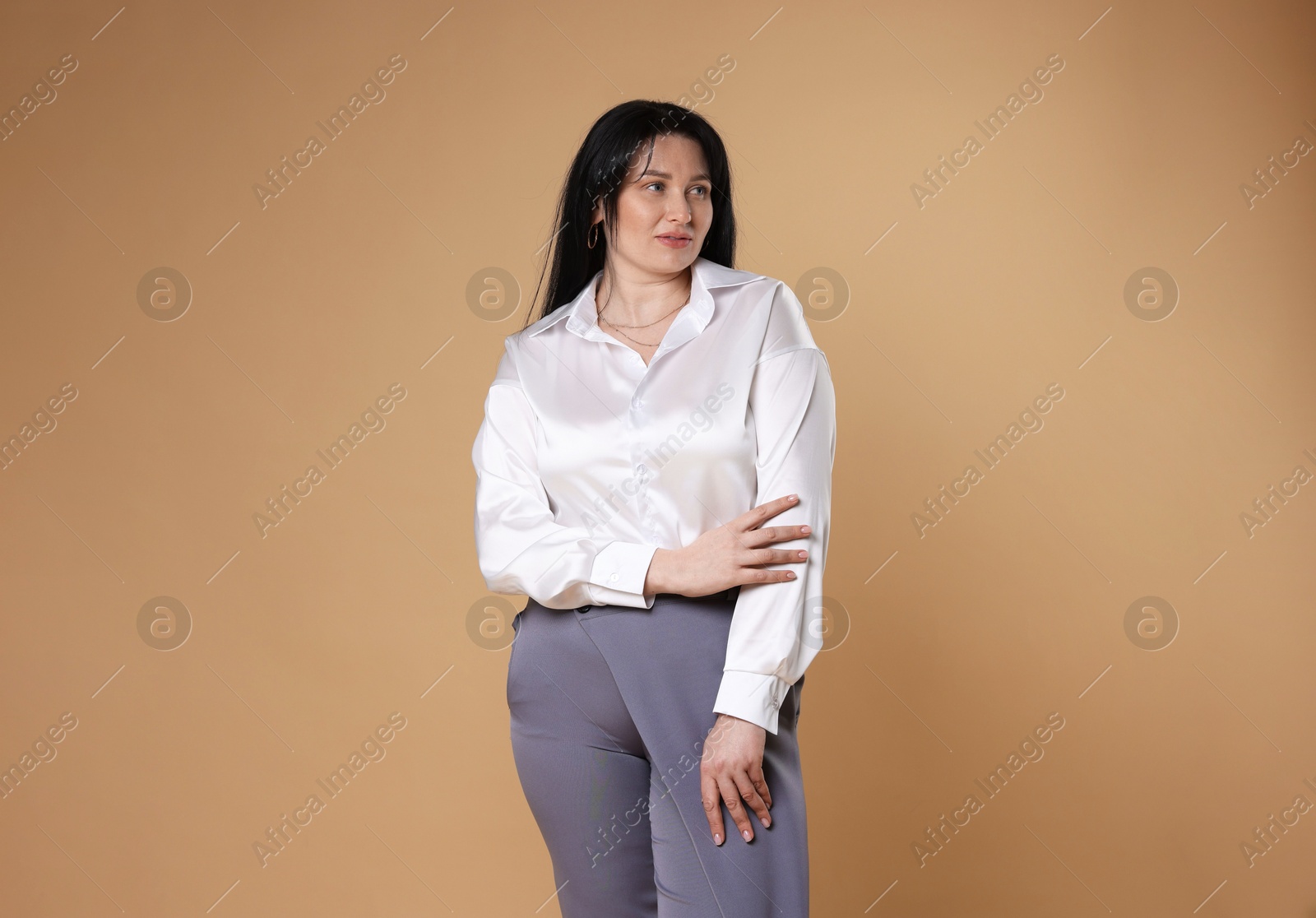 Photo of Charming plus size model on beige background. Overweight