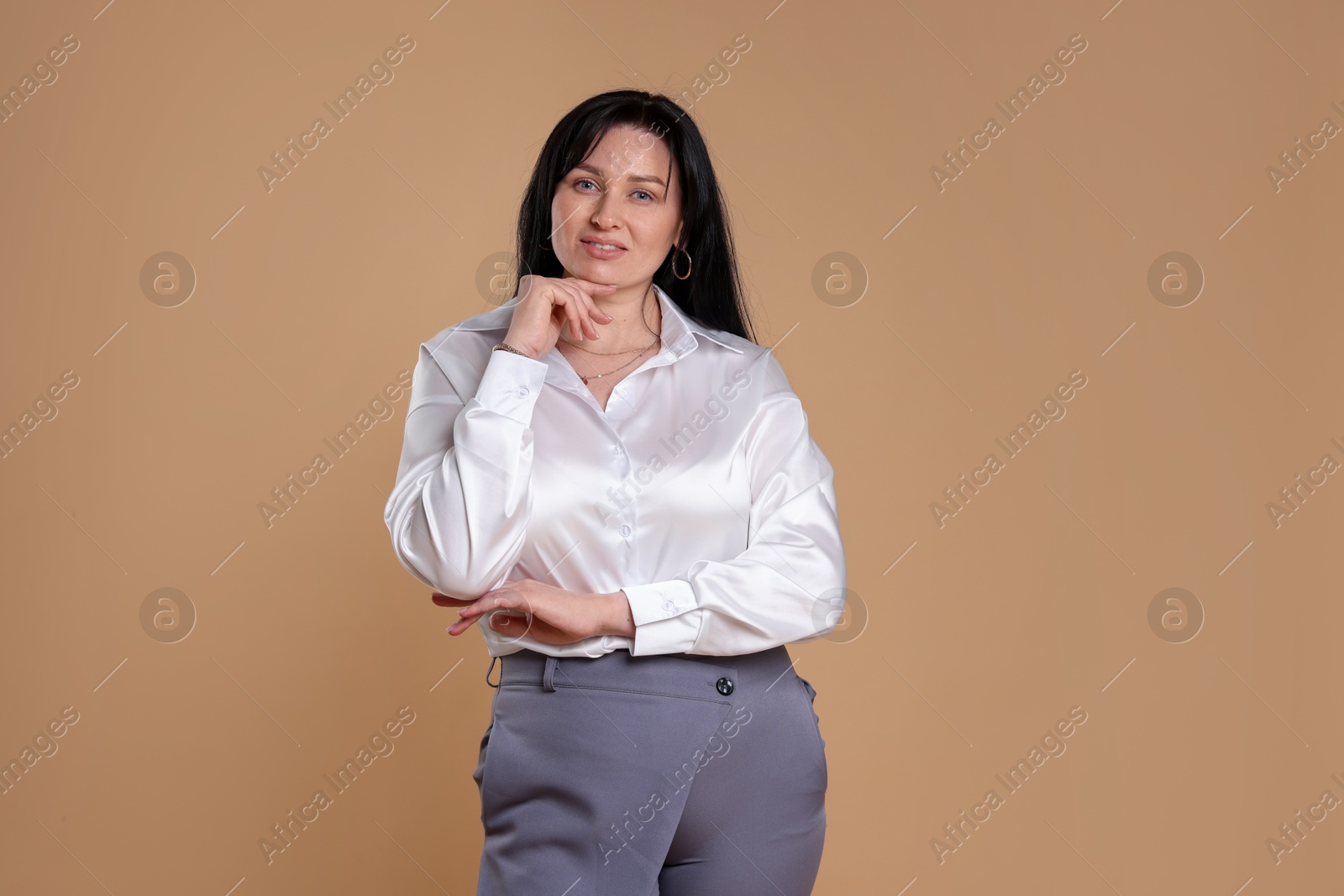 Photo of Portrait of charming plus size model on beige background. Overweight