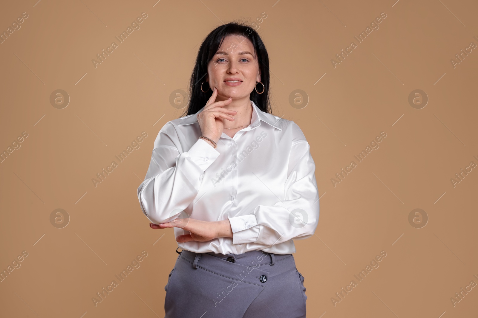 Photo of Portrait of smiling plus size model on beige background. Overweight