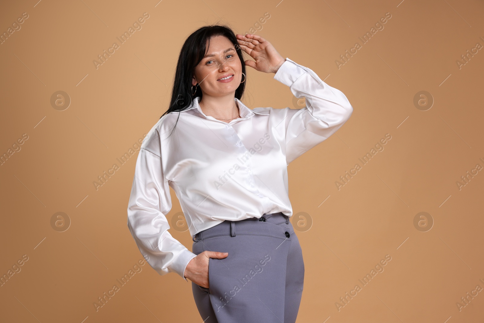 Photo of Portrait of smiling plus size model on beige background. Overweight