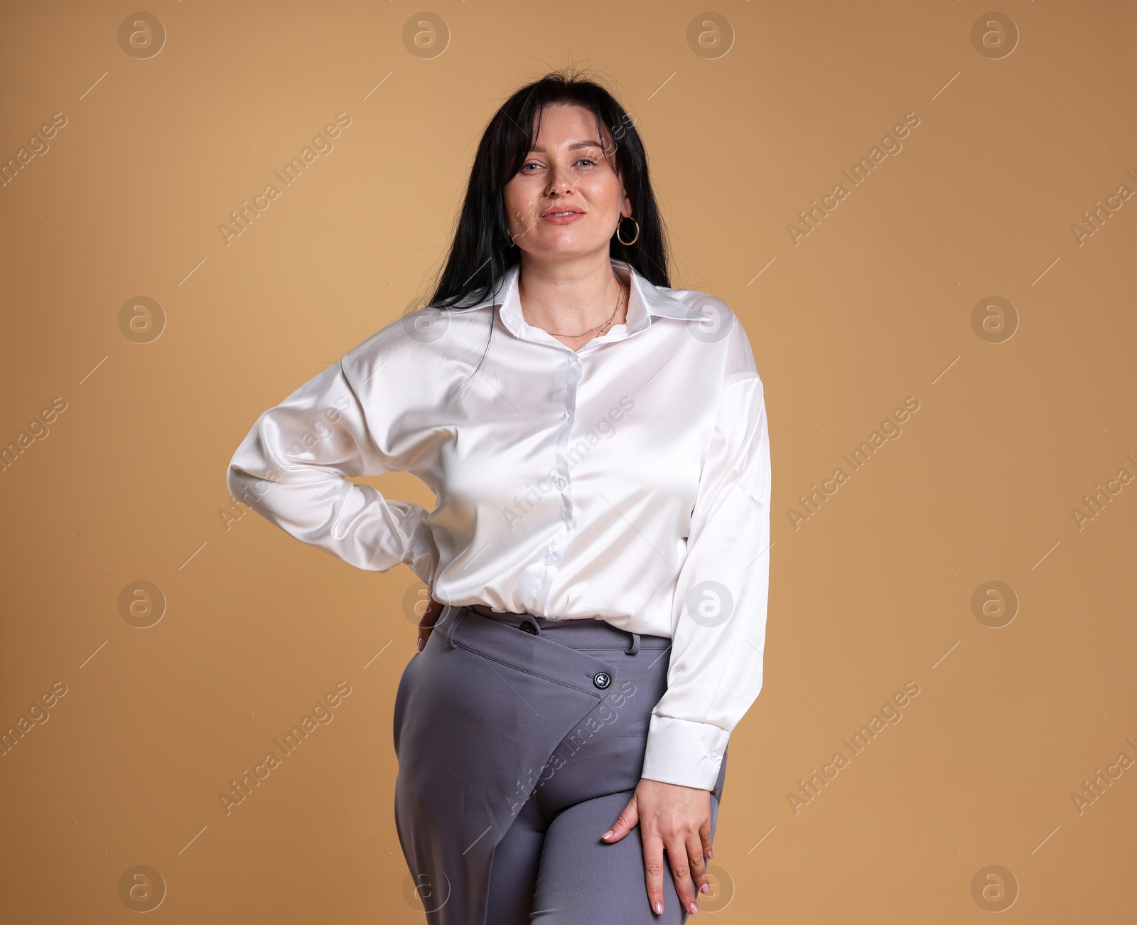 Photo of Portrait of charming plus size model on beige background. Overweight