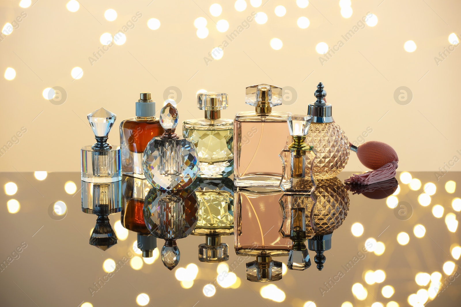 Different luxury perfumes on glass surface. Bokeh effect Photo of Different luxury perfumes on glass surface. Bokeh effect