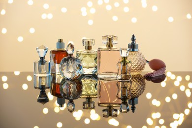 Photo of Different luxury perfumes on glass surface. Bokeh effect