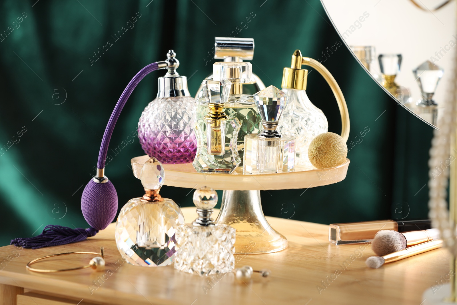 Different luxury perfumes on wooden dressing table indoors Photo of Different luxury perfumes on wooden dressing table indoors