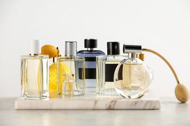 Photo of Different luxury perfumes on color marble table