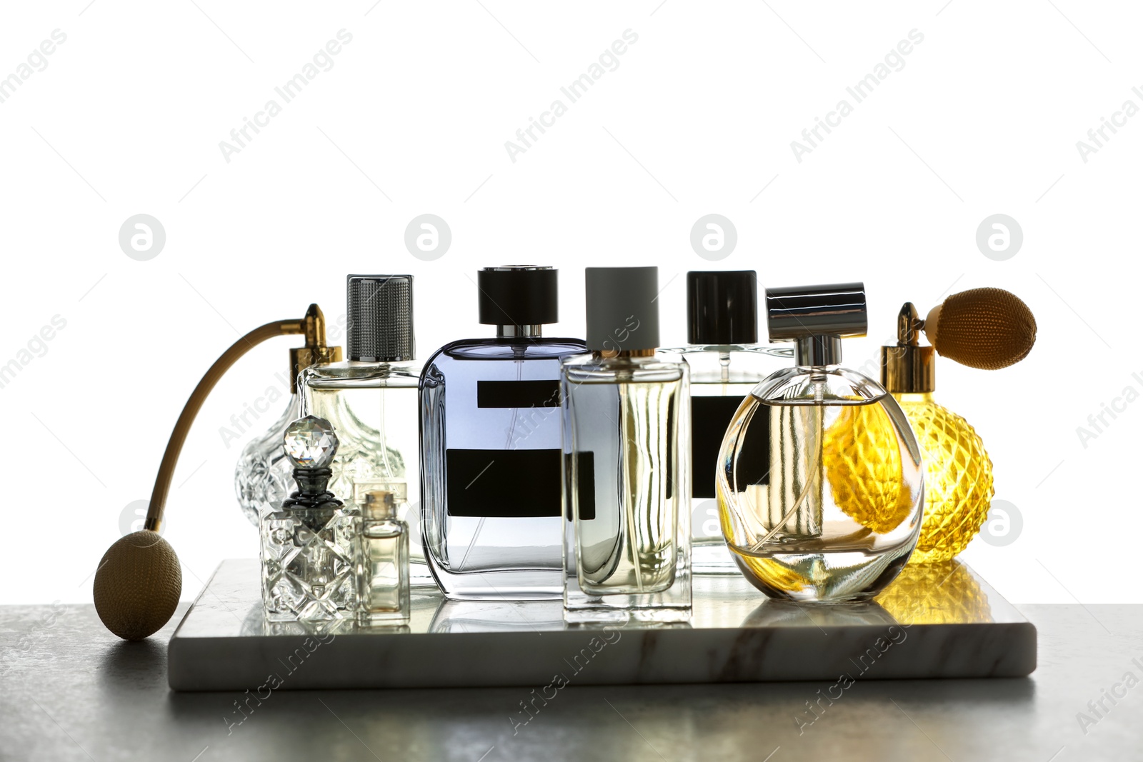 Many different luxury perfumes on grey table Photo of Many different luxury perfumes on grey table