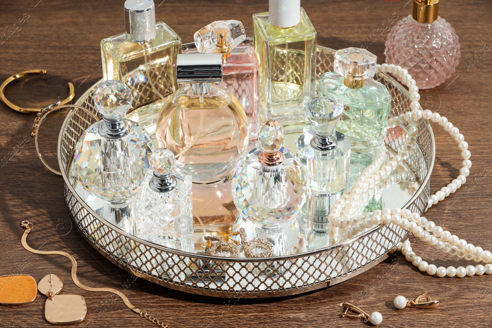 Different luxury perfumes and accessories on wooden table Photo of Different luxury perfumes and accessories on wooden table