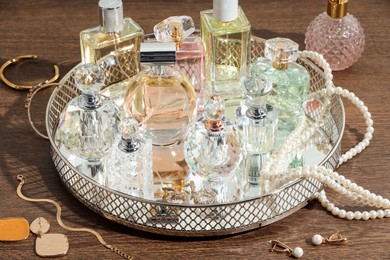 Photo of Different luxury perfumes and accessories on wooden table