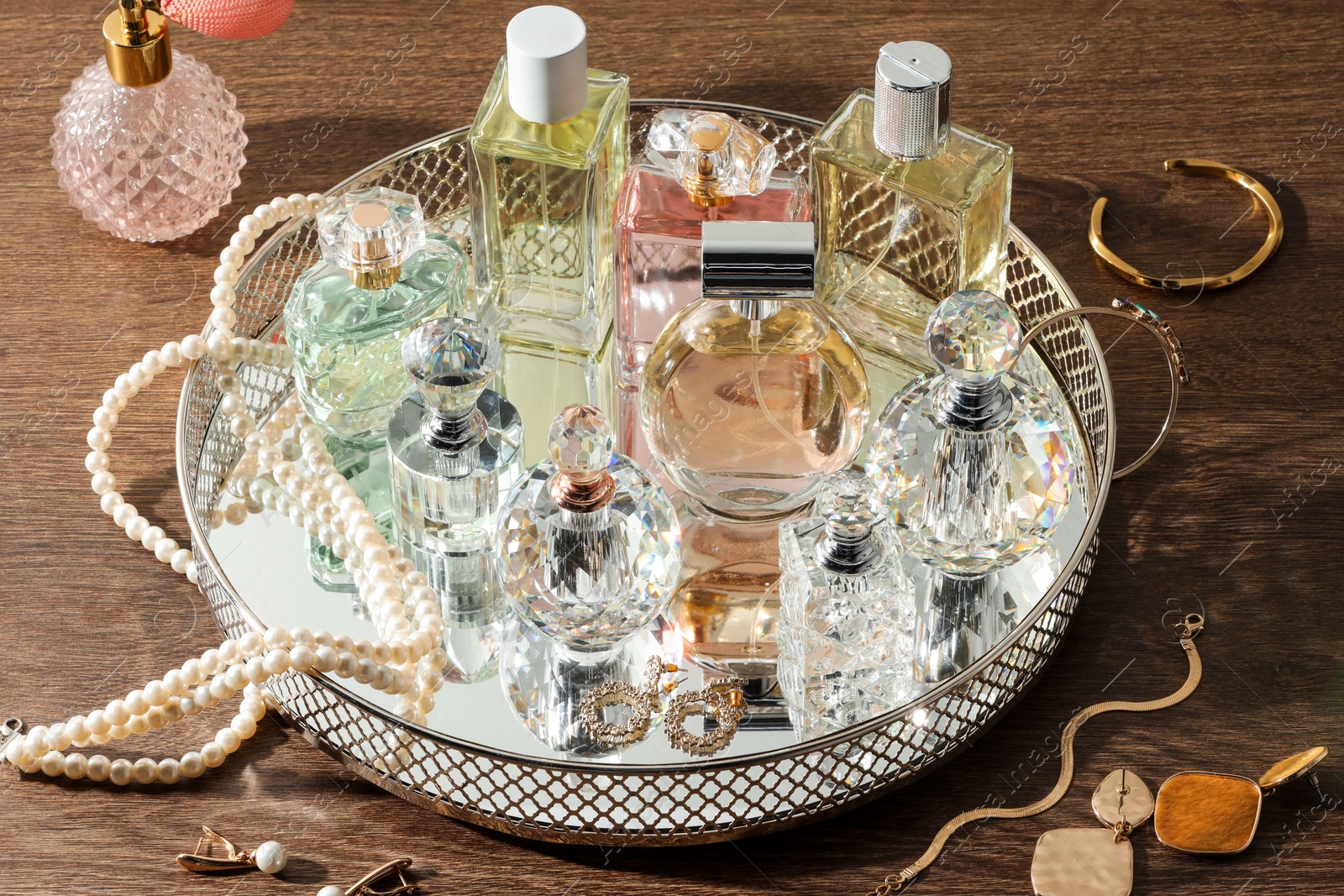 Different luxury perfumes and accessories on wooden table Photo of Different luxury perfumes and accessories on wooden table