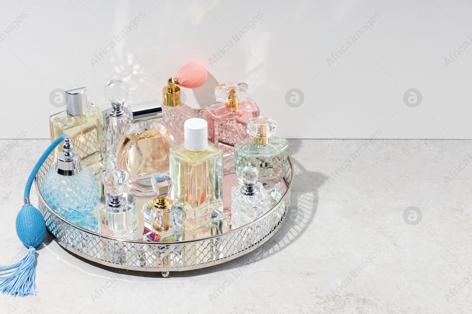 Different luxury perfumes and accessories on light textured table, space for text Photo of Different luxury perfumes and accessories on light textured table, space for text